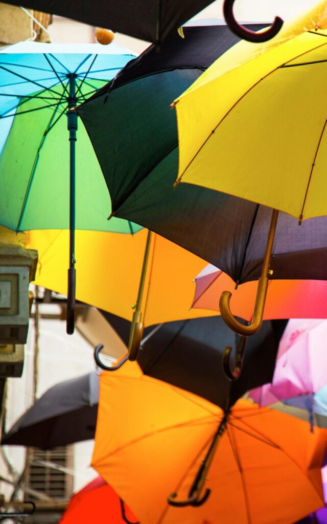 Vibrant display of colorful umbrellas suspended outdoors, creating a lively atmosphere.